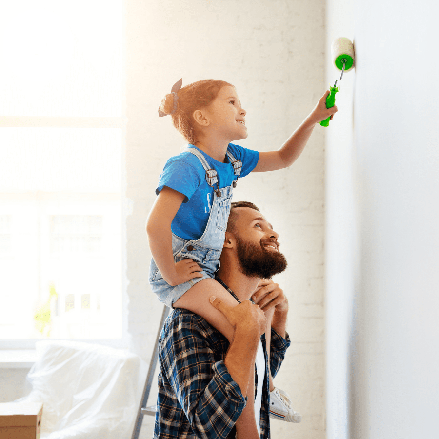 Daughter and father painting wall together