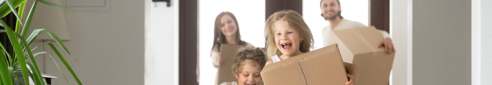 Young family rushing with boxes into house