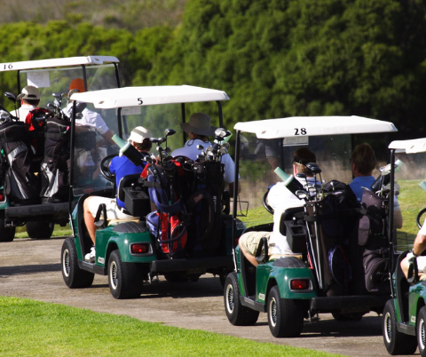 Lineup of golf carts with people in them