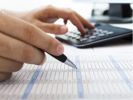 Person checking over statistics with pen and calculator