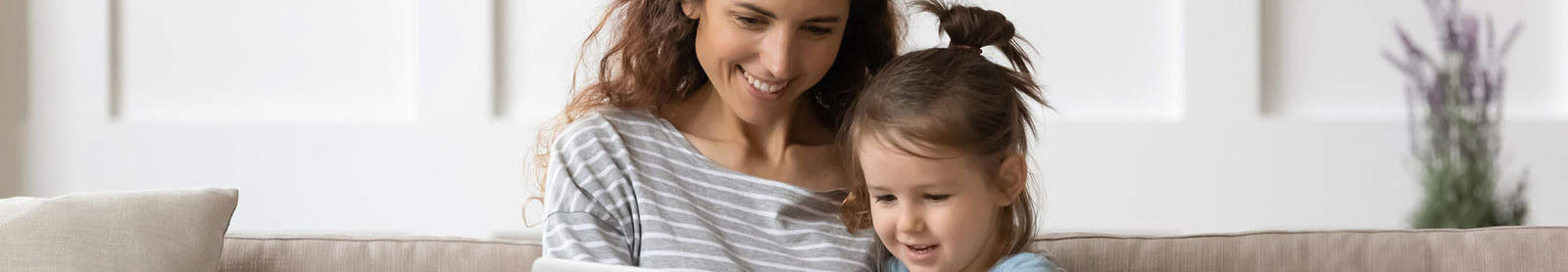 Mother and daughter playing on couch