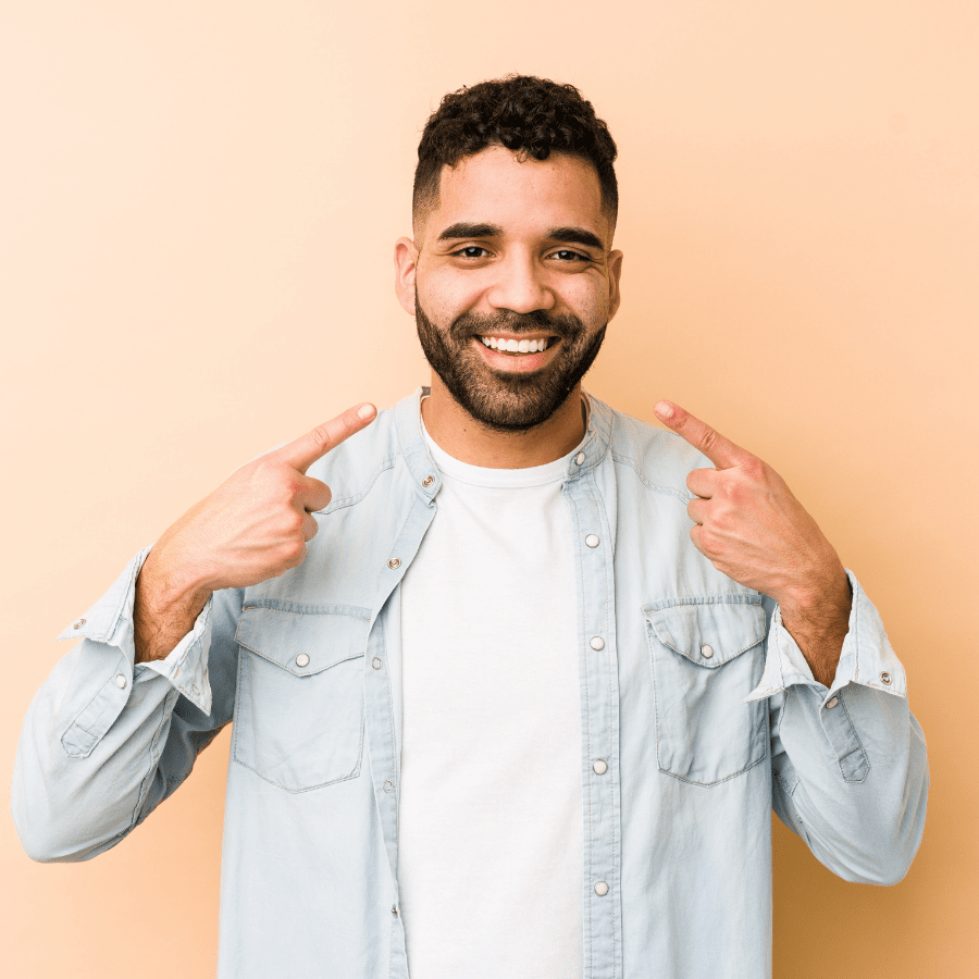 Man pointing to teeth and smiling