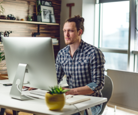 Man with ponytail working at an iMac